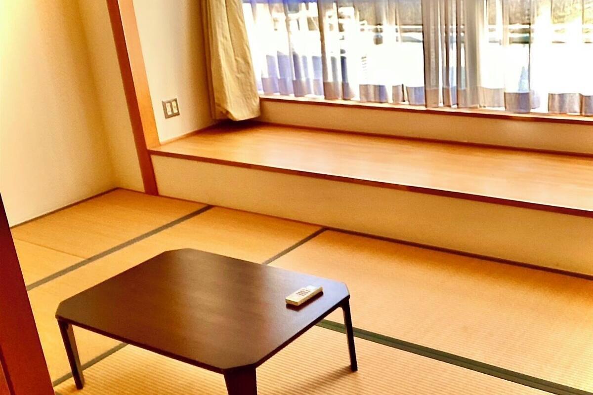 A tatami mat room with a low table and a remote control on it.