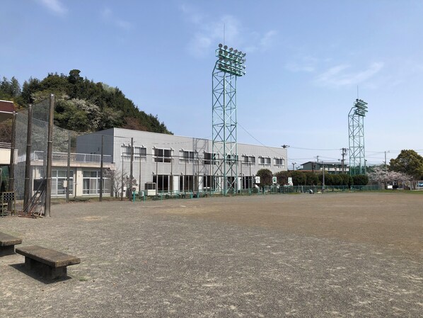 A building with a flat roof, multiple windows, and a fenced area in front.