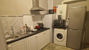Cocina compacta con lavamanos, estufa, microondas y lavadora.