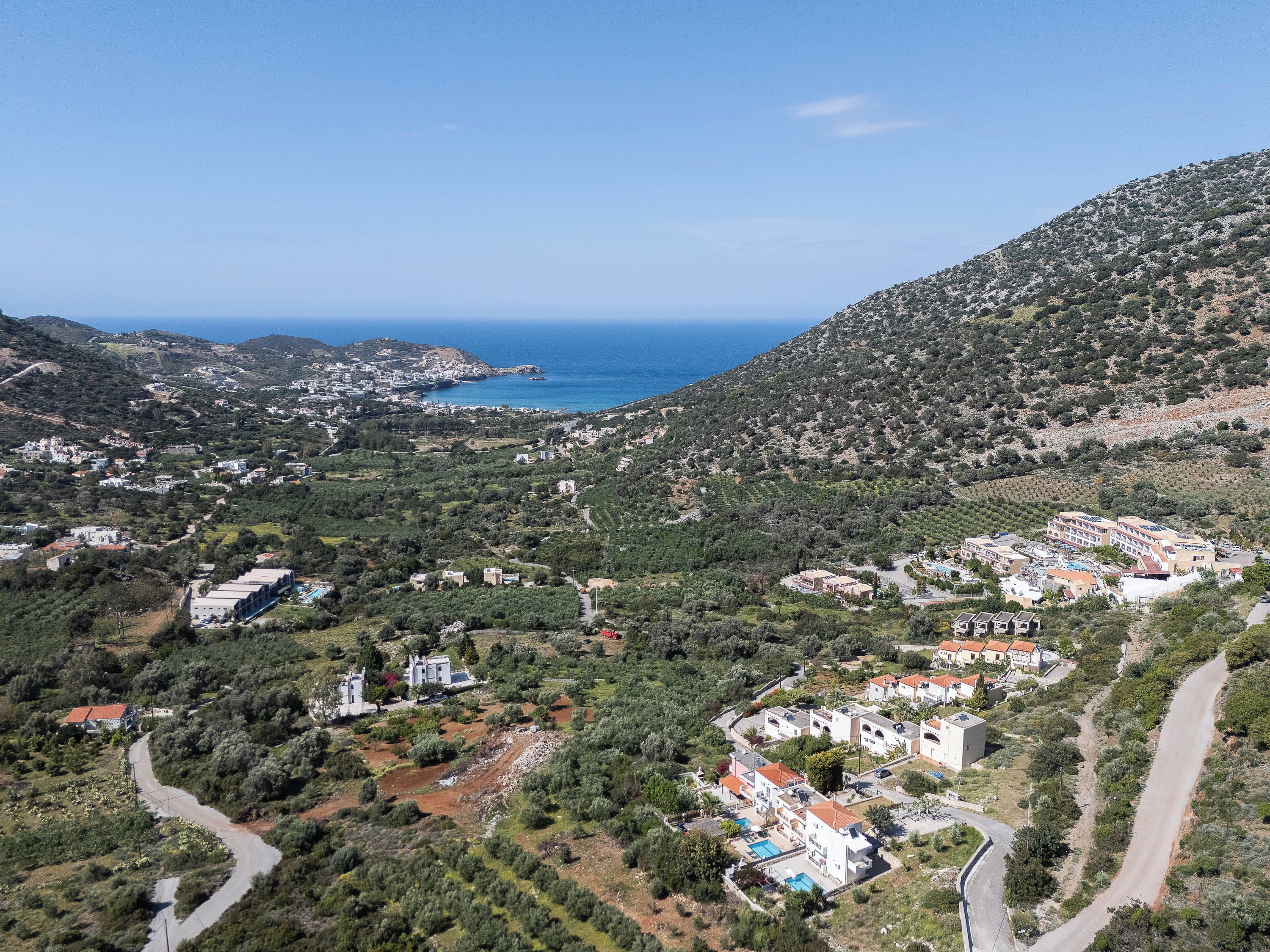 An aerial view of a coastal town with buildings, roads, and a coastline.