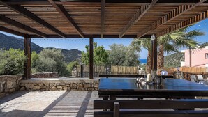 An outdoor patio with a wooden pergola, stone walls, and a table with chairs. - Seaview Villa Marije, By Idealstay Experience (9QRP+JJM Geropotamos, Greece)