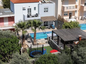 A residential building with a swimming pool, a trampoline, and outdoor seating.
