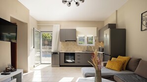 A modern kitchen with a built-in oven and a dining area with a sofa and a coffee table. - Seaview Villa Marije, By Idealstay Experience (9QRP+JJM Geropotamos, Greece)