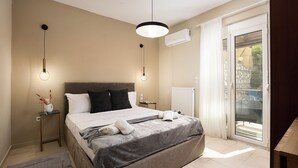 A bedroom with a large bed, two bedside tables, a nightstand, a ceiling light, an air conditioning unit, and a sliding glass door to the outside. - Seaview Villa Marije, By Idealstay Experience (9QRP+JJM Geropotamos, Greece)