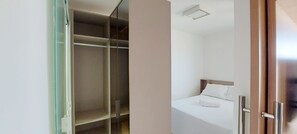 A hotel room with a bed, a closet, and a small bathroom. - COCAZ0101 - Smart Costa Azul (Salvador)