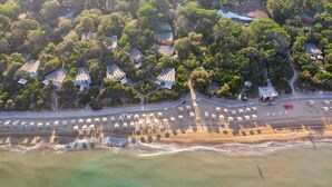 Vista aérea de una zona costera con varios edificios, una carretera y una playa.