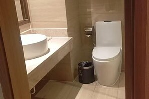A bathroom with a toilet, a sink, and a trash bin. - Vienna Zhihao Hotel (Guangzhou East Station Tianhe Bus Station Subway Station Store) (Guangzhou)
