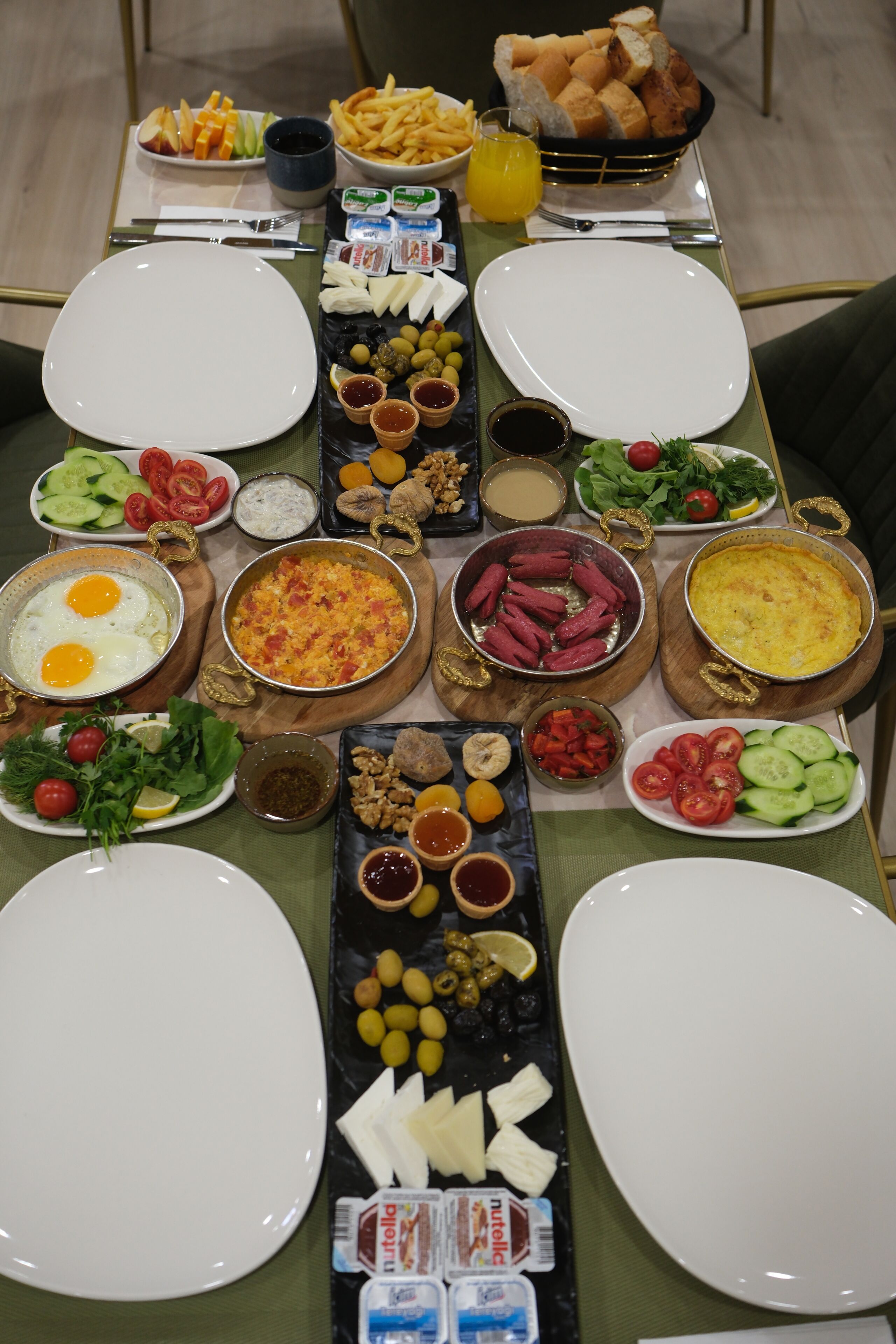 Une table dressée avec divers plats, notamment des œufs, des salades et du pain, et les assiettes et les couverts disposés pour les convives.