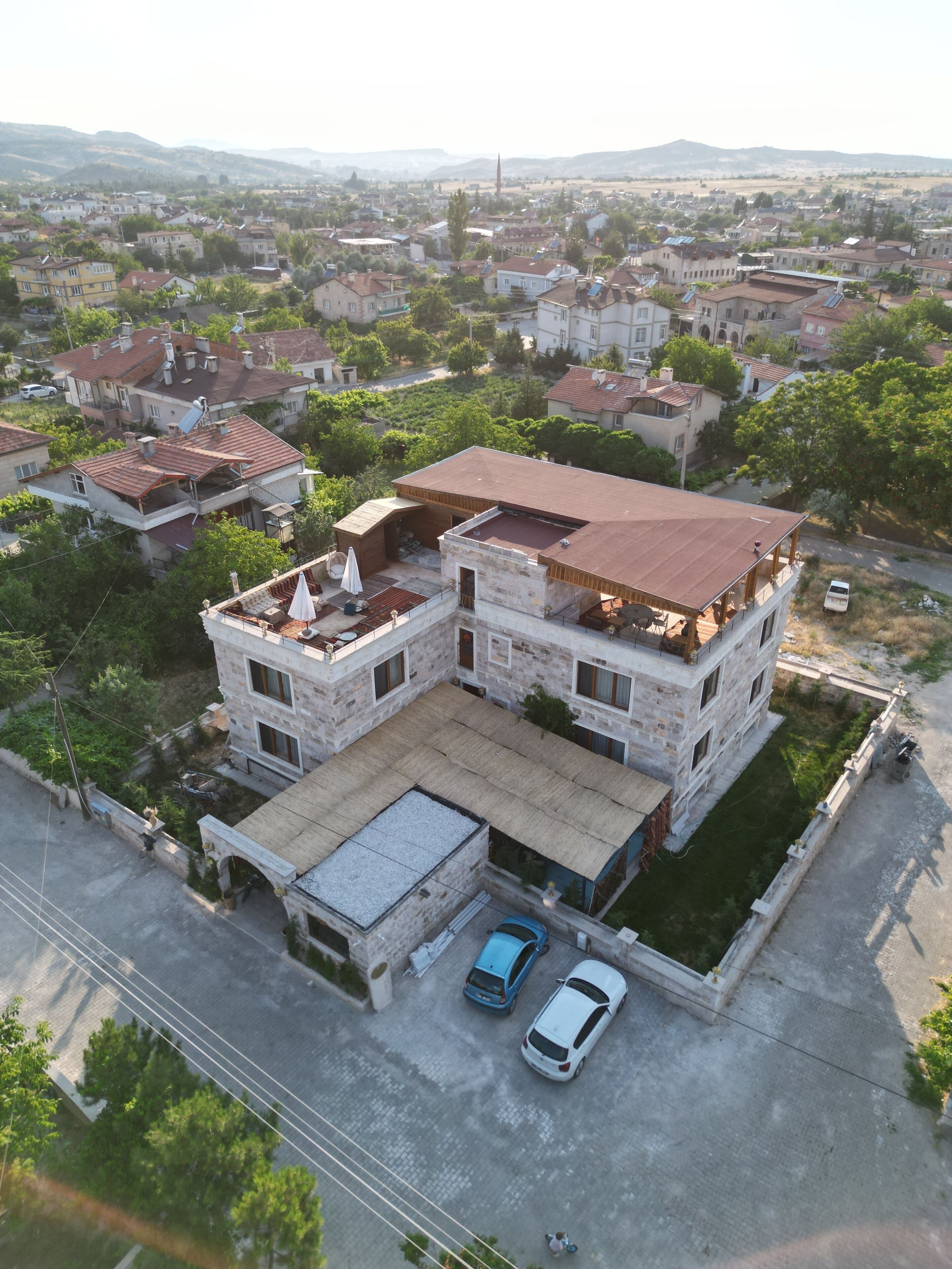 A multi-story building with a flat roof, surrounded by other residential structures.