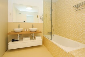 A modern bathroom with a double sink vanity, a glass shower enclosure, and a white bathtub. - Apartment Sleeps 4 With Gym & Spa (Benalmádena)