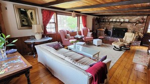 A cozy living room with a fireplace, wooden floors, and comfortable seating.