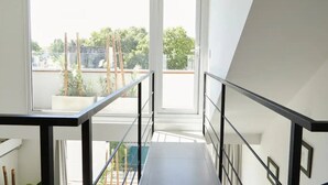 Un interior moderno con una escalera que lleva a un balcón.