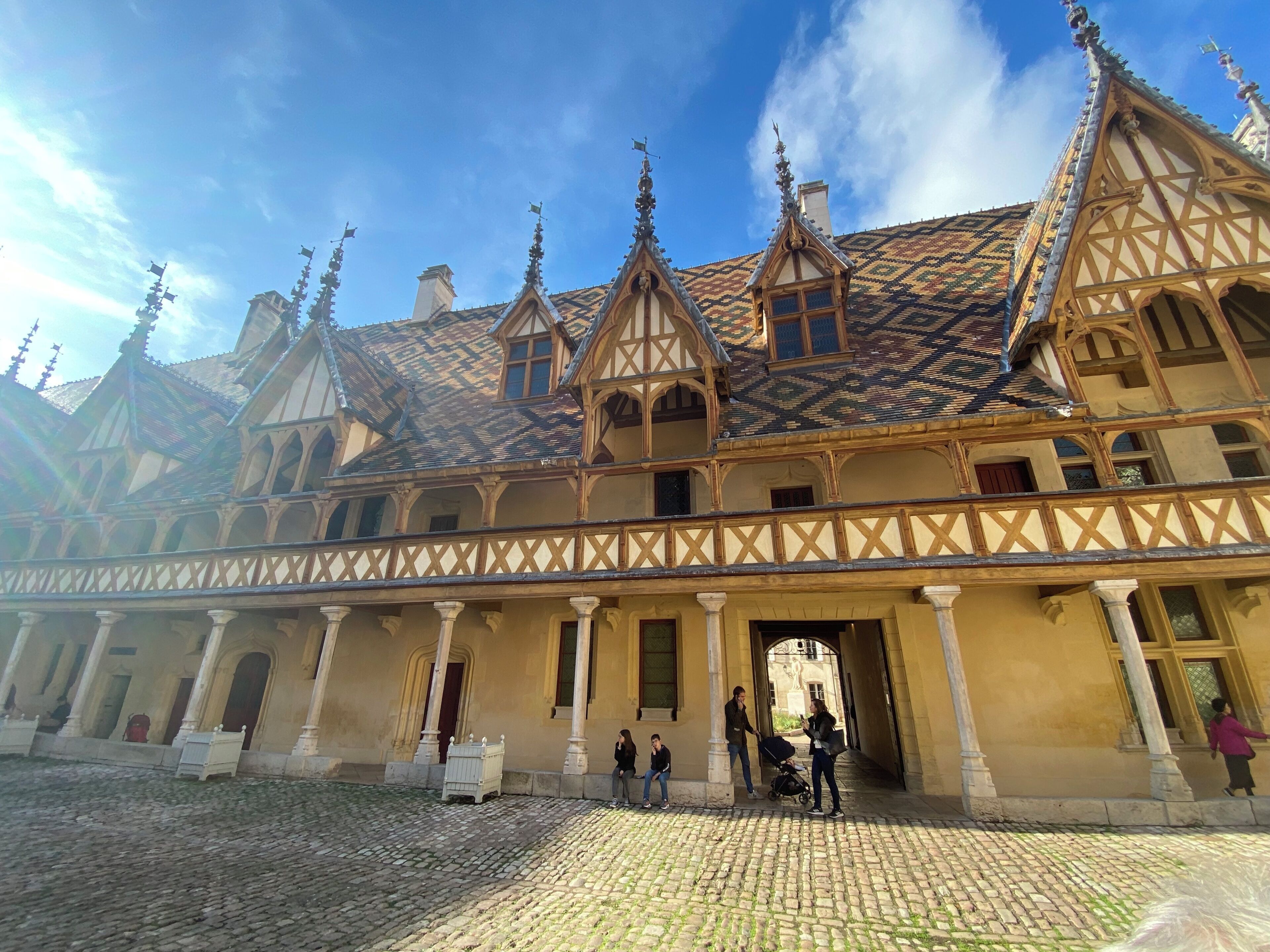 Um edifício histórico com um pátio interior, apresentando um estilo arquitetônico tradicional com estrutura de madeira e telhados inclinados.