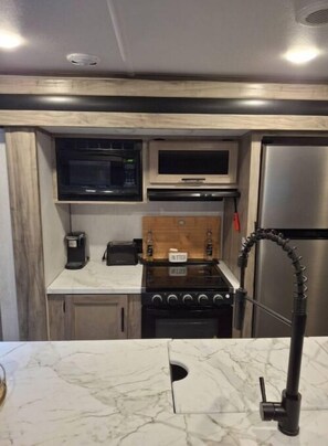 Enjoy cooking in this well-equipped kitchen with a microwave, stove, and refrigerator.
