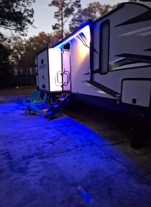 Park your home away from home in this cozy RV, featuring a spacious interior and an open door inviting you to step inside.