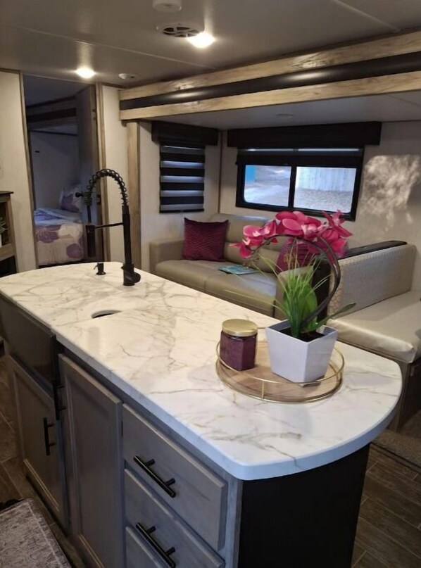 Cozy retreat with a cushioned seating area, sink, and TV.