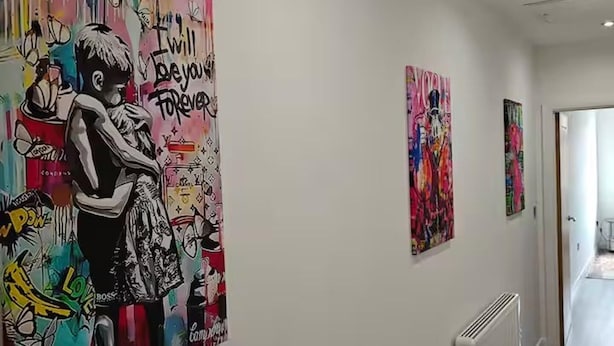 A hallway with a large colorful mural on the left wall and a radiator on the right. - Modern 1Br Sleeps3 - City Centre Location (Leicester)