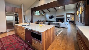 A spacious kitchen with a central island, wooden cabinets, and a built-in oven.