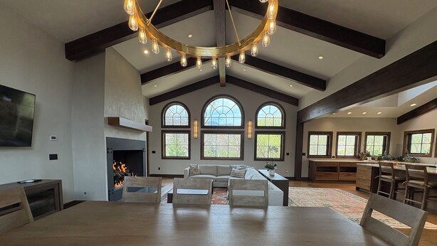 A spacious living area with a fireplace, a dining table, and a kitchen area.