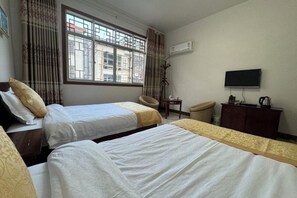 A hotel room with two beds, a TV, a desk, and a chair. - Haozailai Hotel (Yushan)