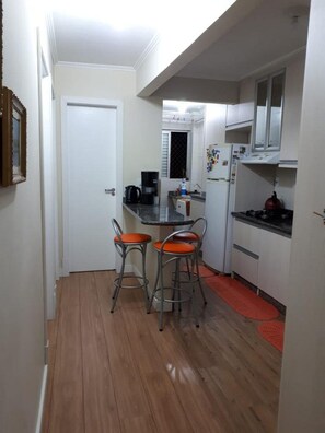 Premium appartement | Privékeuken | Een koelkast, een magnetron, een kookplaat, kookgerei, borden en bestek