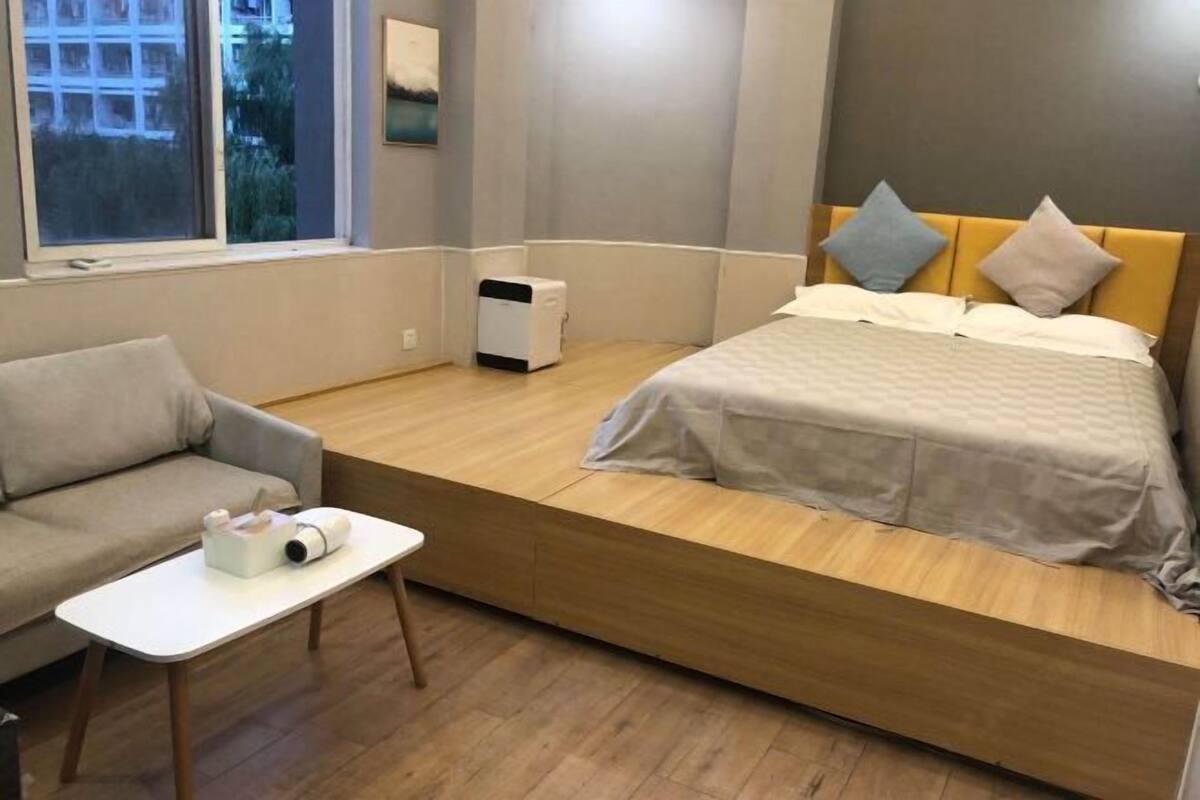 Ein kleines Hotelzimmer mit einem Bett, einer Schlafcouch und einem kleinen Tisch.