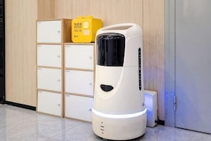 A white coffee machine in a room with wooden cabinets and a white door. - yun jing Hotel (Shanghai Songjiang University Town) (Shanghai)