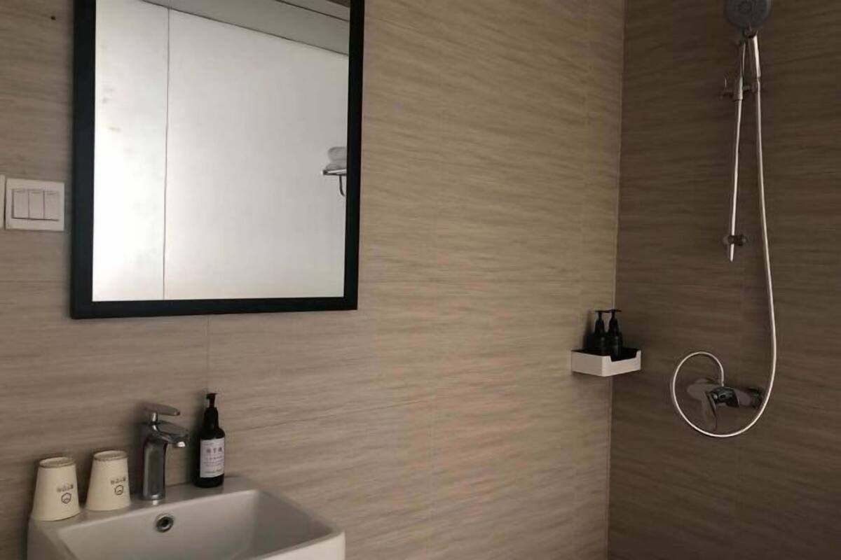 Ein Badezimmer mit Waschbecken, Spiegel und Dusche.