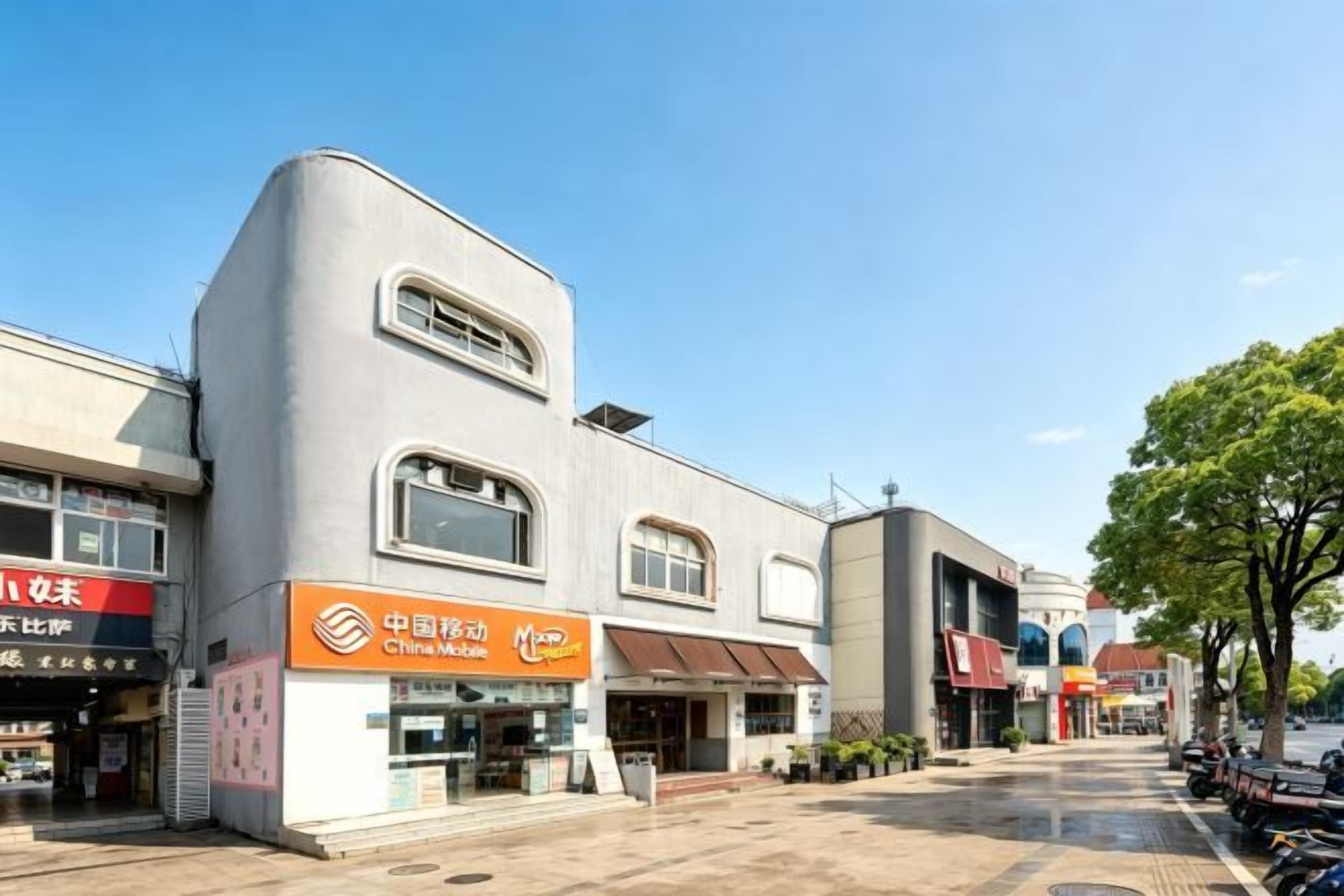Un immeuble commercial doté de plusieurs devantures de magasins, dont une affiche bien visible pour China Mobile.