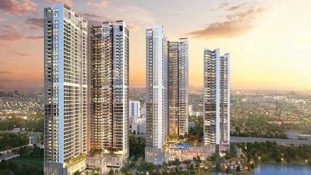 A high-rise residential building complex with multiple towers, a landscaped park area, and a body of water.