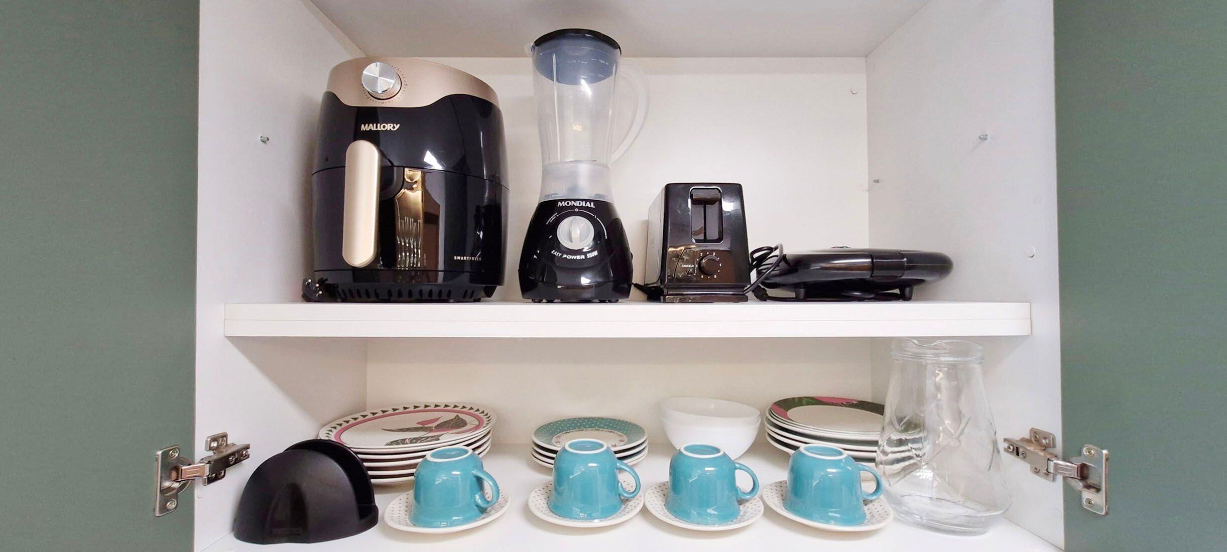 Ein Küchenregal mit einer Kaffeemaschine, einem Mixer, einem Toaster und verschiedenen Geschirrstücken.