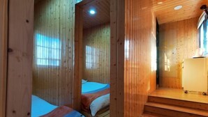 A wooden cabin interior with two beds, a staircase, and a small kitchenette. - Shanghai Yajing Business Hotel (Xinhua Hospital Branch) (Shanghai)
