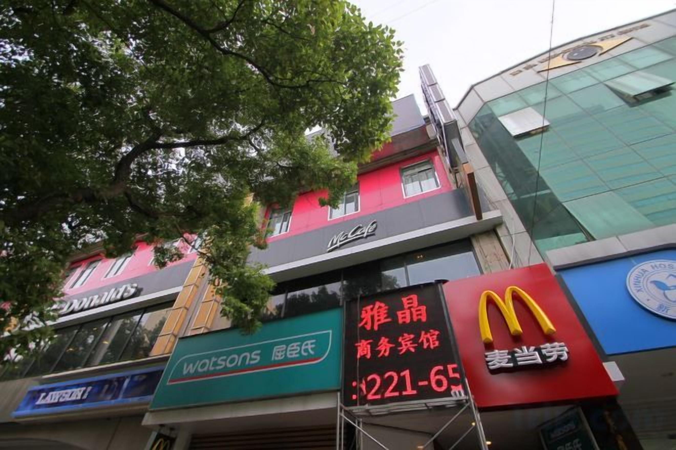 Un edificio comercial con varias fachadas, incluyendo un McDonald's y una farmacia Watsons.