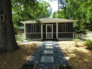residence with a charming porch and beautifully manicured lawn.