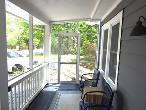 Relax on the covered porch with comfortable seating and a scenic view of the outdoors.