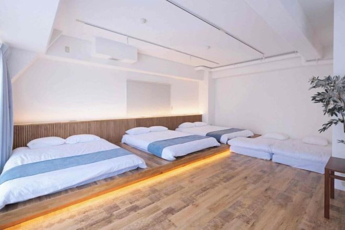 Une chambre d’hôtel moderne avec deux lits, un plancher en bois et une grande fenêtre.