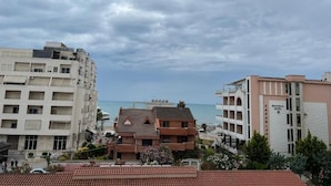Un hôtel avec vue sur la mer, plusieurs étages et un balcon.