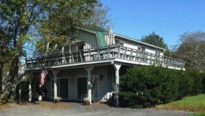 A large, two-story house with a porch and a green roof.