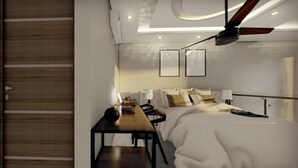 A modern hotel room with a wooden door, a bed with a white duvet, a desk with a lamp, and two framed pictures on the wall. - COSTTA BY YALP (Santa Maria Huatulco)