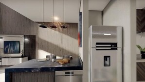 A modern kitchen with a built-in refrigerator, a dining area with a marble countertop, and pendant lighting. - COSTTA BY YALP (Santa Maria Huatulco)