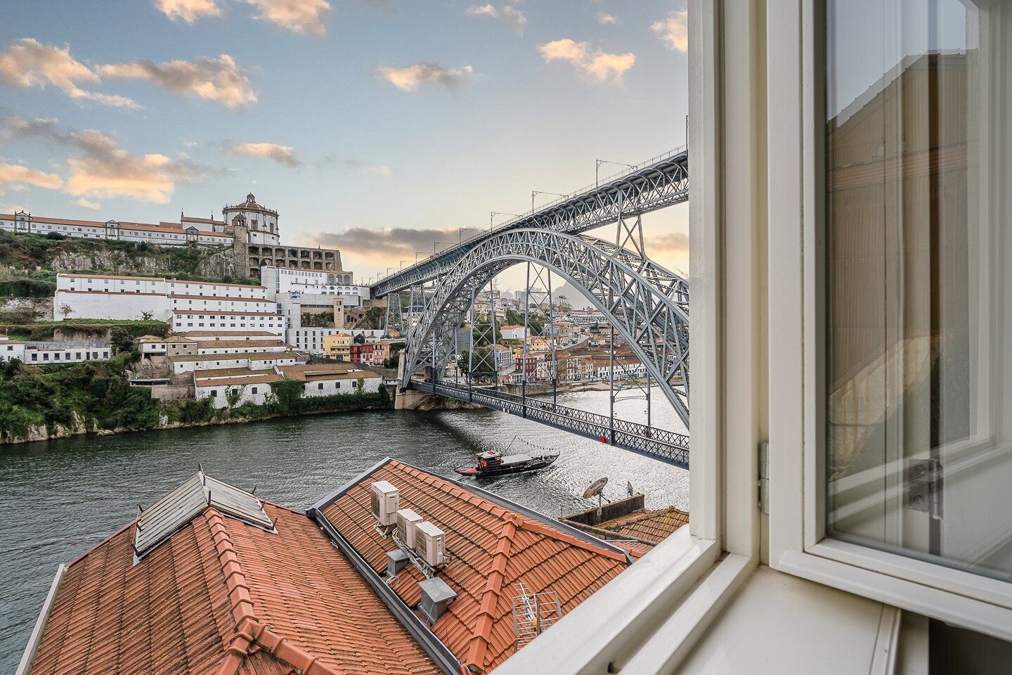 A view of a bridge over a river with buildings on the opposite bank.