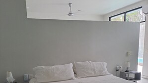 A modern bedroom with a large bed, a bedside table with a lamp, and a nightstand.