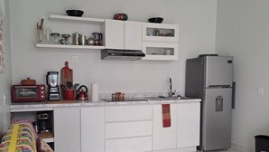 A modern kitchen with white cabinets, a stainless steel refrigerator, and a red toaster.