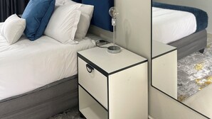 A neatly arranged bedroom with a bed, bedside table, and a mirror reflecting the room. - 36 On Blougom (Midrand)