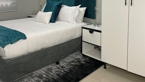 A bedroom with a bed, nightstand, and wardrobe. - 36 On Blougom (Midrand)