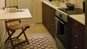 Una cocina compacta con ventana, pileta, cocina y alacenas.