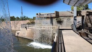 Un élément décoratif aquatique composé d’une structure en béton et de garde-corps en métal.