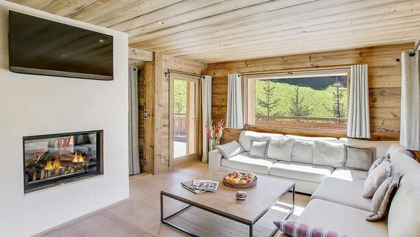 A modern living room with a fireplace, a sofa, and a coffee table. - Chalet, 200m from ski slopes, terrace, balcony, fireplace or stove, parking, tv, ski locker, 200m² (La Clusaz)