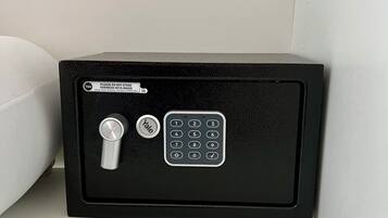 A Yale safe with a combination dial and keypad, placed against a white wall.
