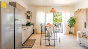 Une cuisine moderne équipée d’un réfrigérateur, d’une cuisinière et d’un coin repas avec des chaises et une table.